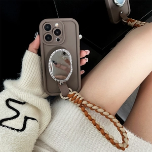 Detail of iPhone case with oval heart mirror and brown braided wrist strap lanyard