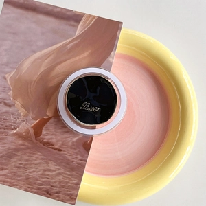 Macro shot of magnetic camellia phone grip with golden Love engraving on black surface