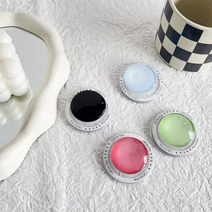 Close-up of circular glass magnetic phone grips with colorful glossy finish and cute icons