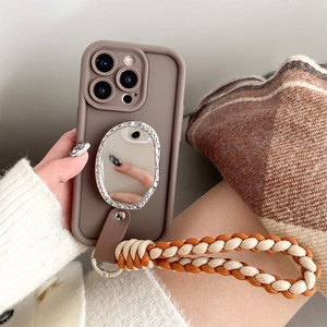 Brown iPhone case featuring an oval mirror with an orange braided wrist strap