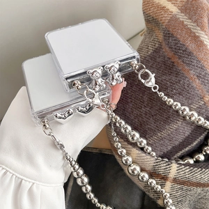 Close-up of a transparent Z Flip case featuring a silver bear charm and beaded hand chain