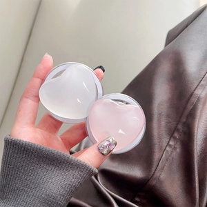 Nahaufnahme von herzförmigen Handy-Halterungen aus Glas in Rosa und Weiß in der Hand