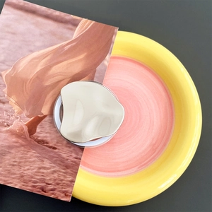 Detail of silver metallic irregular lava drop phone socket on a colorful plate