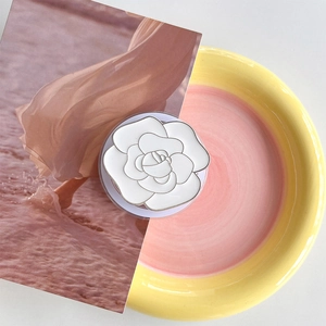 Detail of magnetic white camellia phone socket on decorative ceramic plate
