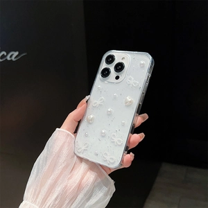 Detail of glitter iPhone case with pearls, white hearts and a ribbon held by hand