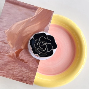 Close-up of elegant black camellia flower magnetic phone grip with silver metal edges