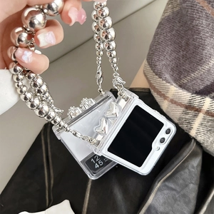 Detail view of Samsung Z Flip6 transparent case with silver metal bead chain and heart