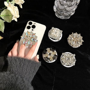 Luxury MagSafe phone grip with rhinestones and pearls on a white smartphone