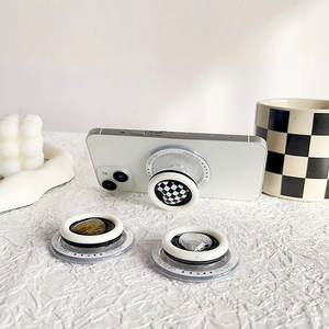 Magnetic MagSafe heart phone grips in checkerboard and foil designs on white desktop