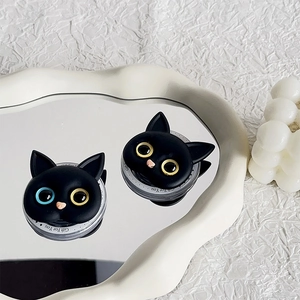 Detail of black cat phone grips with heterochromia eyes on a decorative mirror base