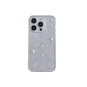 Transparent iPhone case with silver foil, pearl bow and heart decoration on white background