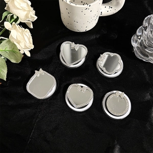 Detailed view of heart and flower-shaped rhinestone phone stands with mirror surface