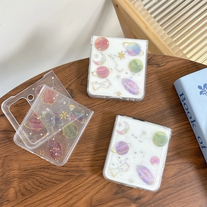 Custodia glitterata con pianeti per Samsung Z Flip 6 su un tavolo in legno rustico