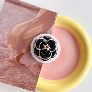 Detail of camellia phone socket with black glossy petals and gold-plated edges