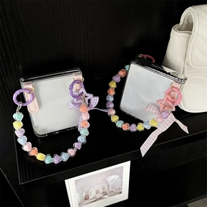 Detail of transparent Galaxy Z Flip 6 case with colorful heart beads and ribbon bow