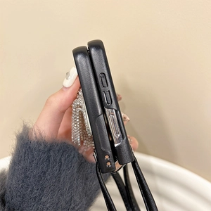 Détail de coque pliable noire avec franges de strass argentés et cordon en cuir