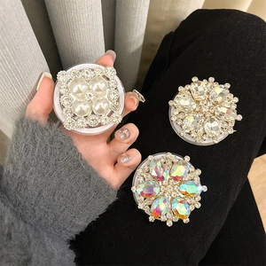 Detailed view of three luxury MagSafe phone grips with pearls, rhinestones, and laser gems