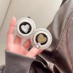 Detail of heart-shaped magnetic phone grips with glitter and fiber textures held in hand