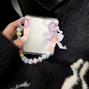 Detail of clear Z Flip 6 case with colorful heart bead strap and purple ribbon bow