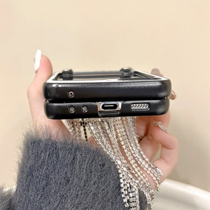 Détail des découpes précises sur une coque pliante noire avec sangle à pompon strass