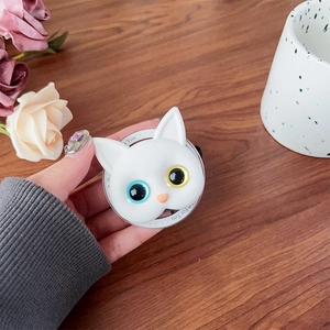 Close-up of white cat head phone socket with blue and yellow eyes on a wooden desk