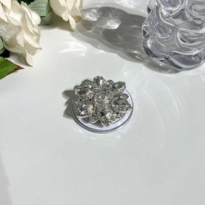 Macro detail of luxury flower rhinestone Magsafe phone grip with crystal sparkling reflections