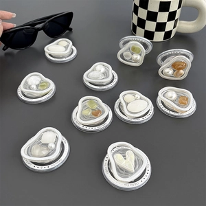 Flat lay of multiple resin stone phone sockets with heart gems and pearl details