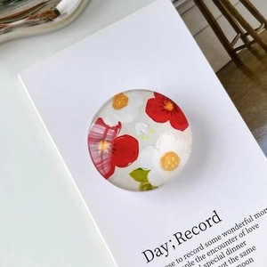 Macro view of crystal phone grip with red and white camellia resin flower pattern