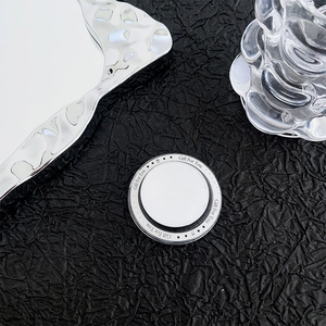 Detail of magnetic glass phone grip with 'Gift For You' text on textured black background