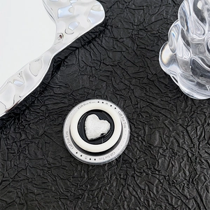Detail of silver heart MagSafe phone grip with Gift For You text on black paper background