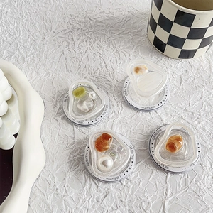 Detail of four magnetic heart-shaped phone grips with pearl and gemstone patterns