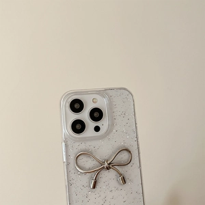 Dettaglio macro della cover iPhone glitterata trasparente con fiocco in metallo argento