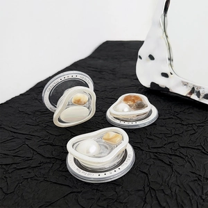 Close-up of heart-shaped pearl and agate stones on magnetic phone socket grips
