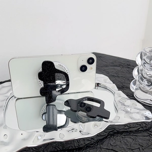Black glitter car-shaped foldable phone socket grip on a white smartphone back