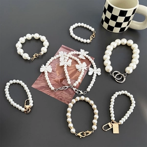 Luxe faux pearl phone strap set with white bows and sparkling gold rhinestone charms