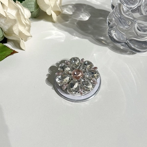 Detail of flower-shaped MagSafe phone grip with pink crystals and clear water drop stones
