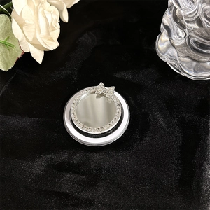 Detail of magnetic phone holder mirror featuring rhinestone bow and silver crystal frame