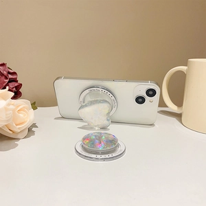 Holographic heart and round phone grip stand on white desk with floral background
