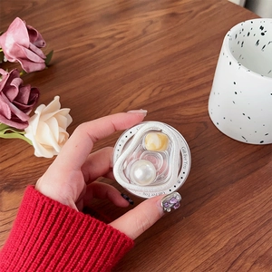 Detailed close-up of a magnetic heart pearl grip-tok phone stand on a wooden table
