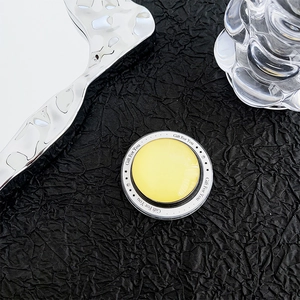 Close-up of yellow glass magnetic phone socket with Gift For You text on black texture