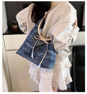Close-up of star-patterned denim shoulder bag with bow detail and beaded drawstring straps
