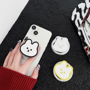 Trois supports de téléphone en forme de lapin sur un smartphone blanc sur fond noir