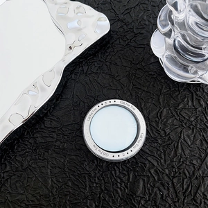 Macro detail of silver round magnetic phone stand with Gift For You engraving and stars