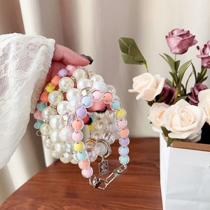 Detailed macro view of colorful beaded phone straps with pearls and vintage metal pendant