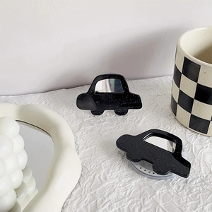 Close-up of black glitter car phone grip with mirror surface on white background