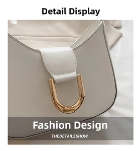 Detail of off-white faux leather shoulder bag with golden U-shaped metal buckle