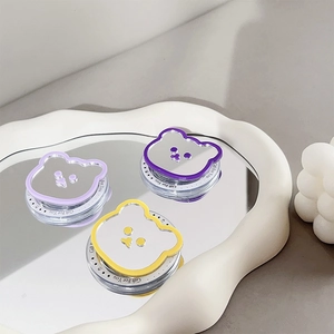 Magnetic bear-shaped mirror phone sockets in purple and yellow on a wavy tray