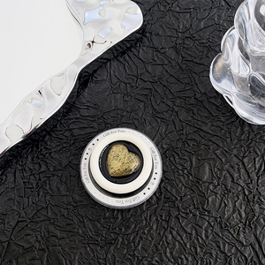 Detail of heart-shaped magnetic phone grip with golden brushed texture and Gift For You text