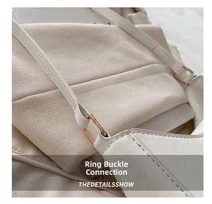 Close-up of white PU leather shoulder bag with gold metal ring and stitched strap detail