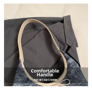 Detailed close-up of blue tweed texture and beige leather handle on the shoulder bag